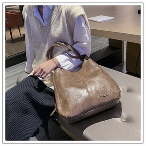 Close-up of deep brown soft leather tote bag with stitching detail and pebble texture