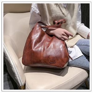 Close-up of brown leather handbag with vintage texture and stitched patch design