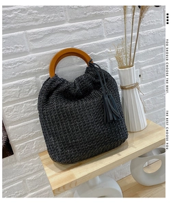 Detail showing black woven texture and natural wood ring handles of the trendy crossbody bag