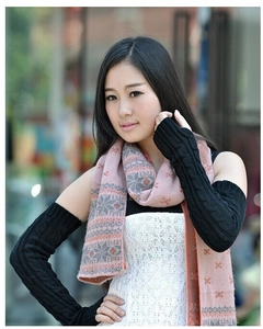 Detail of female model wearing black cable knit long arm warmers in an outdoor setting