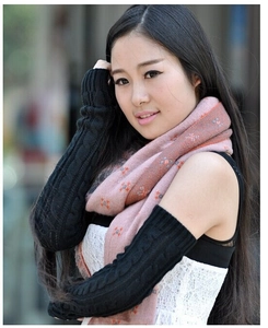 Close-up of black knitted long arm warmers with a chunky cable knit texture