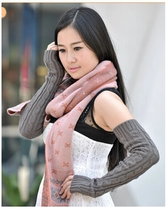 Outdoor shot showing thick grey cable knit long fingerless gloves on a model