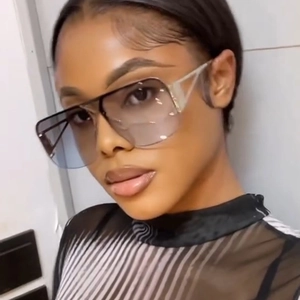 Detailed view of oversized square sunglasses with grey to blue gradient lenses and dark frames