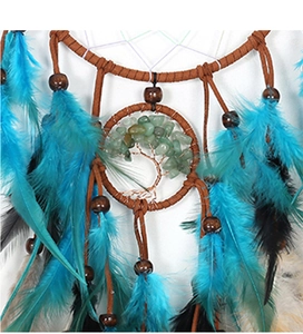 Macro shot of life tree dreamcatcher featuring green stones and blue feathers