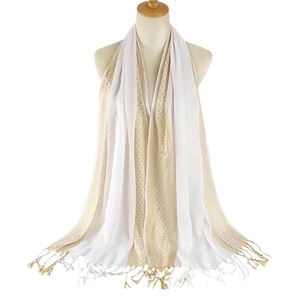 Close-up of white and gold fringed scarf texture with vertical metallic jacquard weave