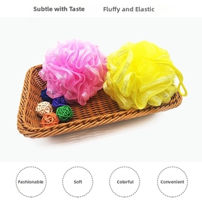 Close-up of soft pink and yellow bath mesh sponges in a basket showing fluffy texture