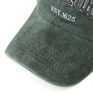 Close-up of green washed cotton baseball cap featuring vintage white EST.1625 embroidery
