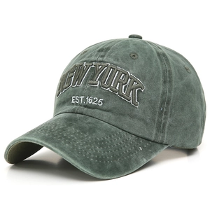 Detailed close-up of dark green washed cotton baseball cap with New York embroidery