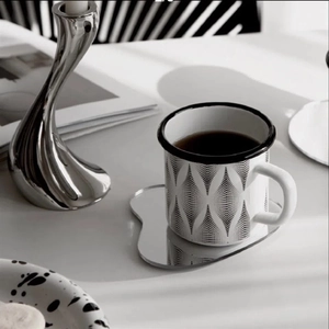 Irregular acrylic mirror coaster with geometric pattern cup on a minimalist white desk