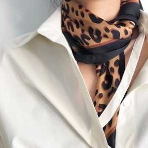 Detail shot of leopard print cotton linen small square scarf tied around the neck