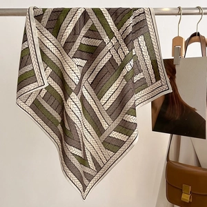 Detailed close-up of a woven pattern silk scarf hanging on a metal hanger for display