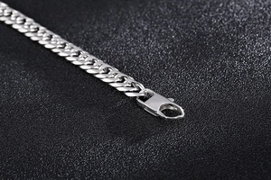 Macro shot of silver titanium steel cuban link chain with secure lobster clasp closure