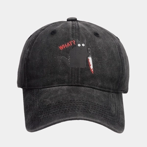 Detail shot of the funny black cat holding a knife embroidery on a washed grey baseball cap