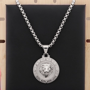 Macro shot of silver lion head pendant with crystal accents on a black leather display