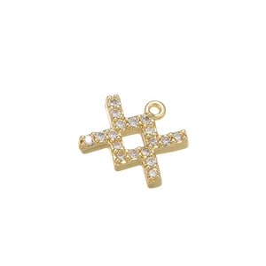 Macro-opname van gouden kruis hanger met zirkonia inlays en kleine lus aan de top