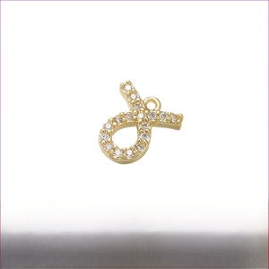 Detail van de 8x8mm gouden infinity hanger met zirkonen ingelegd op een messing basis