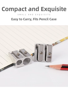 Close-up of portable dual-hole metal pencil sharpener on a notebook in office setting