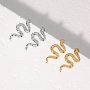 Detailed close-up of snake earrings showing intricate scale texture in gold and silver