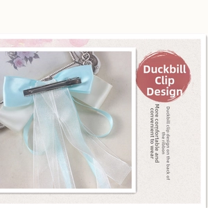 Detail of the metal duckbill clip on a light blue and cream silk ribbon hair bow