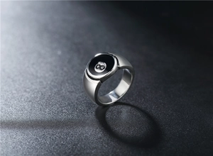 Close-up of a silver titanium steel ring featuring a black 8-ball billiard design