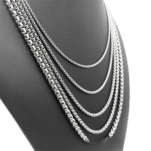 Detail of silver box chain necklaces in five different thickness levels on a neck model