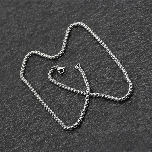 Detailed view of silver stainless steel box chain with lobster clasp on dark background