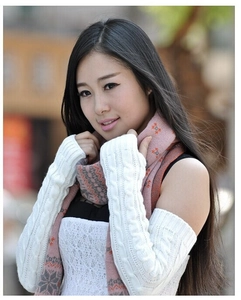 Detailed knit texture of long white cable-knit arm warmers and snowflake scarf