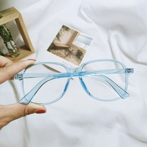 Detailed close-up of light blue translucent retro glasses frame with vintage square design