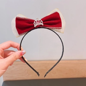 Detailed view of a red velvet bow headband with a gold crown and mesh accents