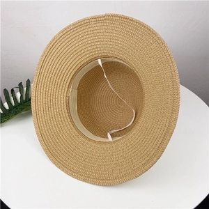 Inside view of a khaki straw sun hat featuring an inner sweatband and elastic chin strap