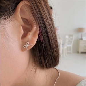 Elegant 925 sterling silver bow stud earrings with woven texture on model's ear