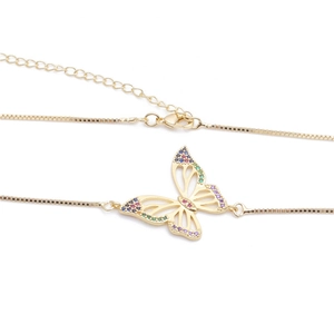 Detail of gold butterfly necklace with colorful zircon wings and box chain clasp