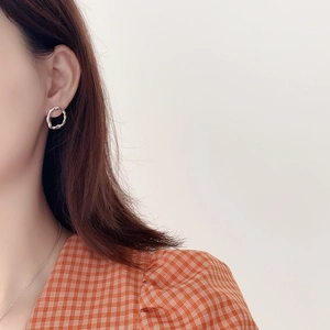 Detail of silver wavy textured hoop earrings on model featuring minimalist irregular design