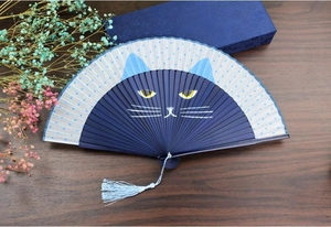 Detail of blue cat face pattern on a Japanese folding fan with a matching silk tassel