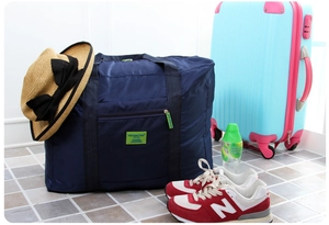 Dettaglio della borsa da viaggio pieghevole blu scuro con etichetta tessuta verde