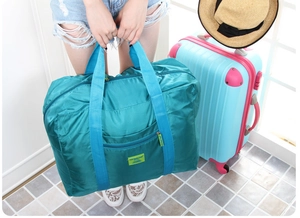 Dettaglio della borsa da viaggio impermeabile ciano con tasca a zip e manici in nylon