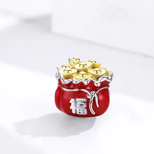 Macro shot of red enamel lucky bag charm with gold sycee and silver fortune character