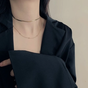 Double-layered gold stainless steel snake chain and beaded necklace on a model