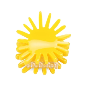 Macro detail of sun-shaped yellow acetate hair claw with glossy finish and clear teeth