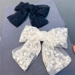Detailed embroidery texture on double-layer lace bow hair clips in black and beige