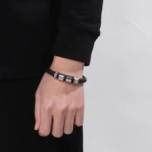 Close-up of black braided leather bracelet with silver beads on a male wrist