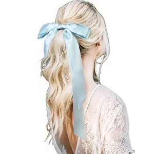Elegant light blue satin oversized bow hair clip with long ribbons shown on model