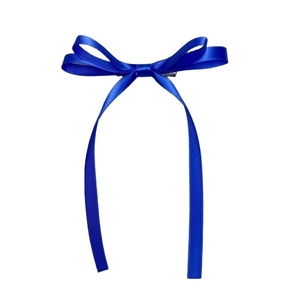 Detail showing the royal blue satin bow hair clip with elegant long ribbon streamers
