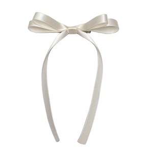 Detailed view of the creamy white satin double-layered bow hair clip with long ribbons