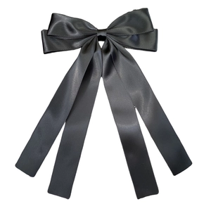 Detailed view of the layered black satin bow hairclip with long flowing ribbons
