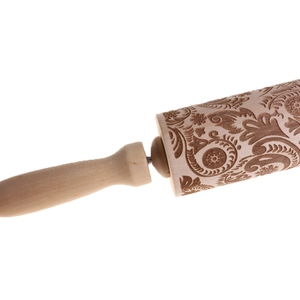 Close-up of floral pattern engraving on a wooden rolling pin for baking cookies