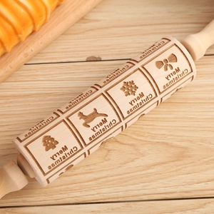 Macro view of Christmas engraved wooden rolling pin with reindeer and snowflake patterns