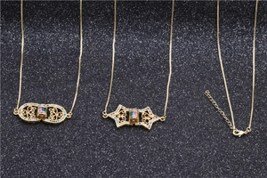 Detailed close-up of golden owl pendant necklaces with micro-set colorful zircons