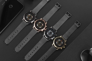 Detail view of four men's quartz watches with Milanese mesh straps in various metallic colors