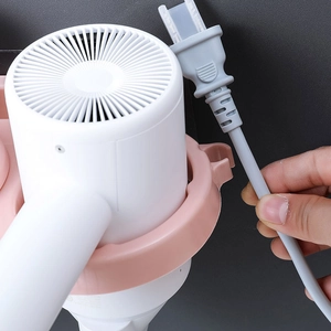 Pink wall-mounted hairdryer holder with cord hook for bathroom storage and organization